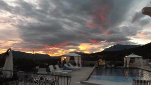 a sunset over a swimming pool on a resort at Luštica Apartments in Luštica
