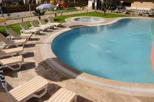 a large swimming pool with lounge chairs next to it at Yenisey Residence 2 in Mahmutlar