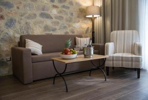 a living room with a couch and a table with a bowl of fruit at Thassos Grand Resort in Alyki