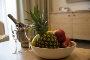 a bowl of fruit on a table with wine glasses at Thassos Grand Resort in Alyki