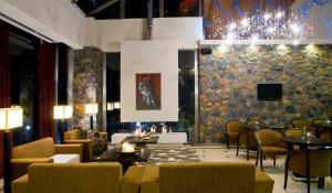 a lobby with tables and chairs and a chandelier at Domotel Neve Mountain Resort in Palaios Agios Athanasios