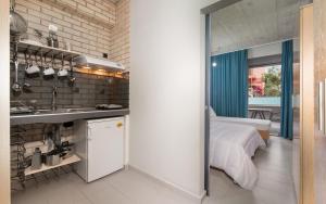 a kitchen and a bedroom with a bed and a sink at Erifili at Sarti Agora Apartments & Studios in Sarti