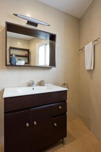 W łazience znajduje się umywalka i lustro. w obiekcie Villa Leomar w Maladze