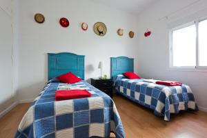 duas camas num quarto com azul e branco em Villa Leomar em Málaga
