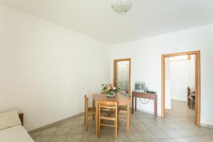 una stanza con tavolo, sedie e specchio di Residenza Piccolo Uliveto a San Menaio