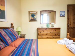 sypialnia z łóżkiem, komodą i lustrem w obiekcie Villetta Rombi w mieście Calasetta