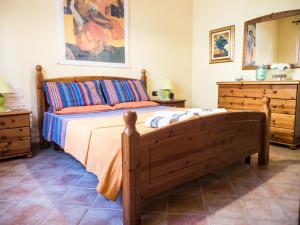 1 dormitorio con cama de madera y vestidor en Villetta Rombi, en Calasetta