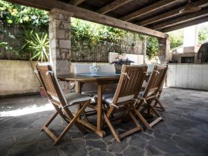 una mesa de madera y sillas en un patio en Villetta Rombi, en Calasetta