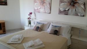 a bedroom with a bed with two towels on it at Cabà Holiday Bardolino Gritti in Bardolino