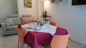 a dining room table with a purple table cloth at Cabà Holiday Bardolino Gritti in Bardolino