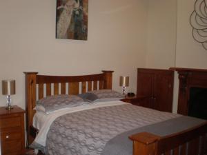 1 dormitorio con 1 cama y una pintura en la pared en The Palms en Gawler