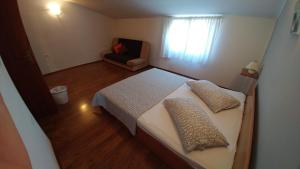 mała sypialnia z łóżkiem i krzesłem w obiekcie Guest House Ilic w mieście Loborika