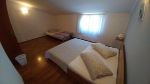 mała sypialnia z dwoma łóżkami i oknem w obiekcie Guest House Ilic w mieście Loborika +26 zdjęć