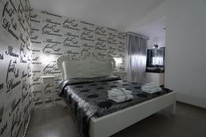 a bedroom with a wall with writing on the wall at B&B Nacorè in Massafra