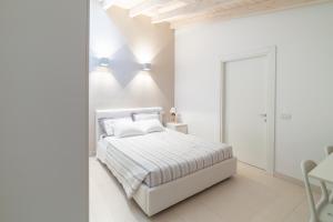 Dormitorio blanco con cama y mesa en La Betulla, en Mantua