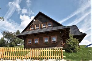 een houten huis met een hek ervoor bij Chata u strýka Joža in Terchová +6 foto's