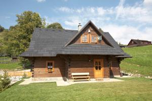 een klein huis met een zwart dak op een veld bij Chata u strýka Joža in Terchová