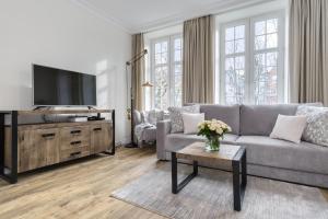 uma sala de estar com um sofá e uma televisão em Elite Apartments Świętego Ducha Prestige em Gdansk