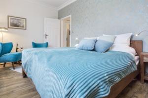 sypialnia z łóżkiem z niebiesko-białymi prześcieradłami w obiekcie Elite Apartments Świętego Ducha Prestige w Gdańsku