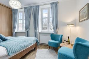 sypialnia z łóżkiem i dwoma niebieskimi krzesłami w obiekcie Elite Apartments Świętego Ducha Prestige w Gdańsku
