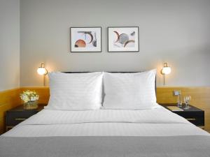 a bedroom with a white bed with two night stands at K+K Hotel Fenix in Prague