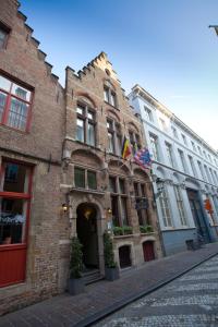 a brick building with a flag on it on a street at Hotel Malleberg in Bruges
