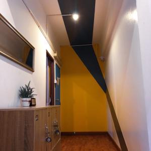 a hallway with a yellow wall in a room at U2 & i-smile Hostel in Chiang Mai