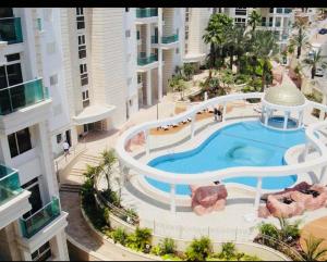 Una vista aérea de un edificio con piscina. en LOVELY 2BR GOLF RESIDENCE EILAT, en Eilat