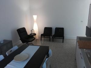 a room with two chairs and a bed and a lamp at Via Stazione 5 in Praia a Mare