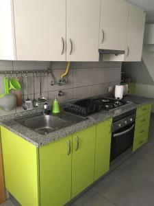 - une cuisine avec des armoires vert citron et un évier dans l'établissement Casa Da Baixa, à Faro