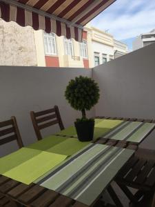 a table with a potted tree sitting on a balcony at Casa Da Baixa in Faro