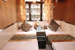 a train room with two beds and a window at Temple Street Hotel in Hong Kong