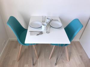a white table and chairs with plates and glasses on it at Hotel Nuka in Ilulissat
