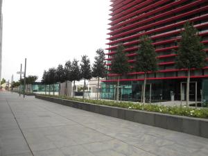 an empty sidewalk next to a tall red building at Best Western Plus Net Tower Hotel Padova in Padova