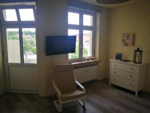 uma sala de estar com uma cadeira e uma televisão de ecrã plano em Casa Herkules em Kassel