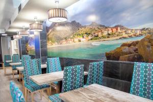 Un restaurante con mesas y sillas con vista al mar. en Hospedium Morada da Moa, en O Pindo