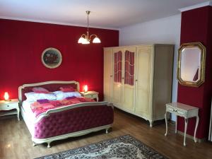 ヴァルデックにあるFerienhaus Seesternの赤い壁のベッドルーム(ベッド1台、鏡付)