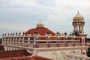 un bâtiment avec une tour d'horloge au sommet dans l'établissement ChidambaraVilas, Chettinad - A Luxury Heritage Resort Hotel, Karaikudi, à Kānādukāttān