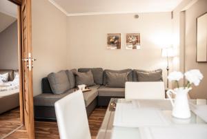 uma sala de estar com um sofá e uma mesa em Gimnazjalna 5 - Apartamenty i pokoje w Centrum Zakopanego em Zakopane