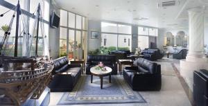 a lobby with leather couches and a table with flowers at Resort Sur Beach Holiday in Sur