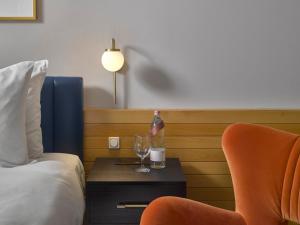 a hotel room with a bottle and a glass on a table at K+K Hotel Fenix in Prague