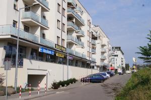 a large building with cars parked in front of it at Apartament Kniaziewicza - Komfortowe Noclegi in Piaseczno