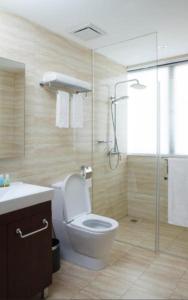 馬尼拉的住宿－ACE套房酒店，一间带卫生间和玻璃淋浴间的浴室