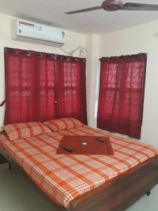 łóżko w pokoju z czerwonymi zasłonami w obiekcie Sterling Homes Near Apollo/Shankara w mieście Ćennaj