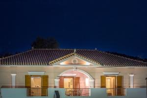 a house at night with the lights on w obiekcie Aquarella Luxury Apartment w Argasio