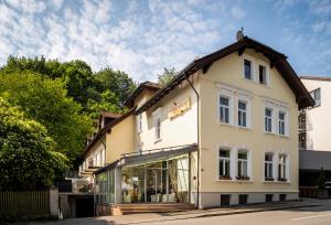 a large white building with glass windows at Hotel Spitzberg Garni in Passau