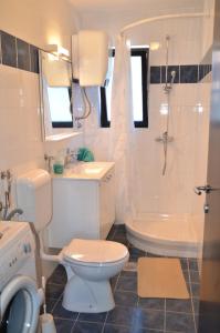 łazienka z toaletą, umywalką i wanną w obiekcie Apartments Ana City w Rovinj +37 zdjęć