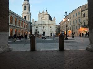 a building with a clock tower in the middle of a street at Hotel Pellegrino E Pace in Loreto