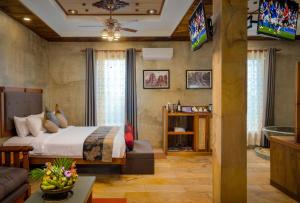 1 dormitorio con 1 cama, TV y sofá en Model Temple Resort & Spa, en Siem Reap