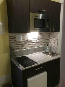 een keuken met een spoelbak en een magnetron bij Las Flores studio 4 in Playa de las Americas +27 foto's